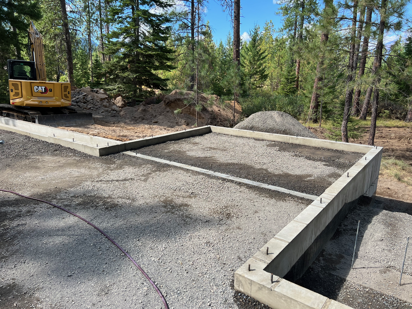 Concrete stem-wall foundation with CAT excavator