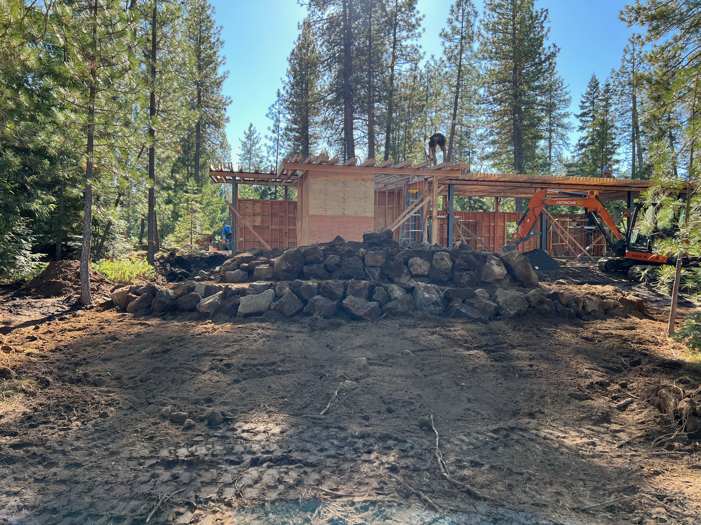 Rock retaining wall with building framing